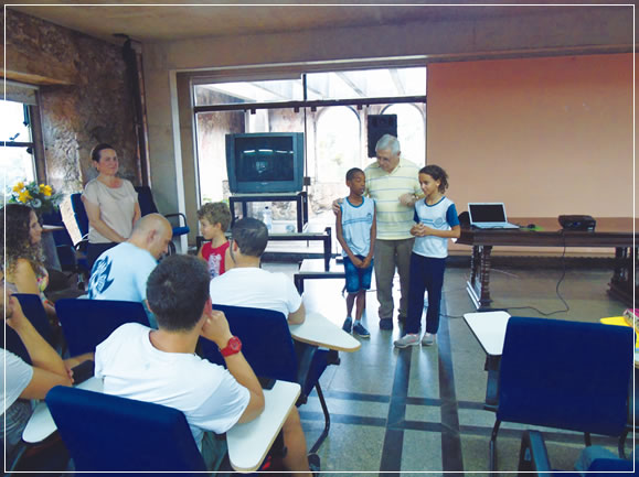 Padre Lauro Palú ajudando (traduzindo) os meninos a explicarem o trabalho deles na escola para os estudantes da Itália.